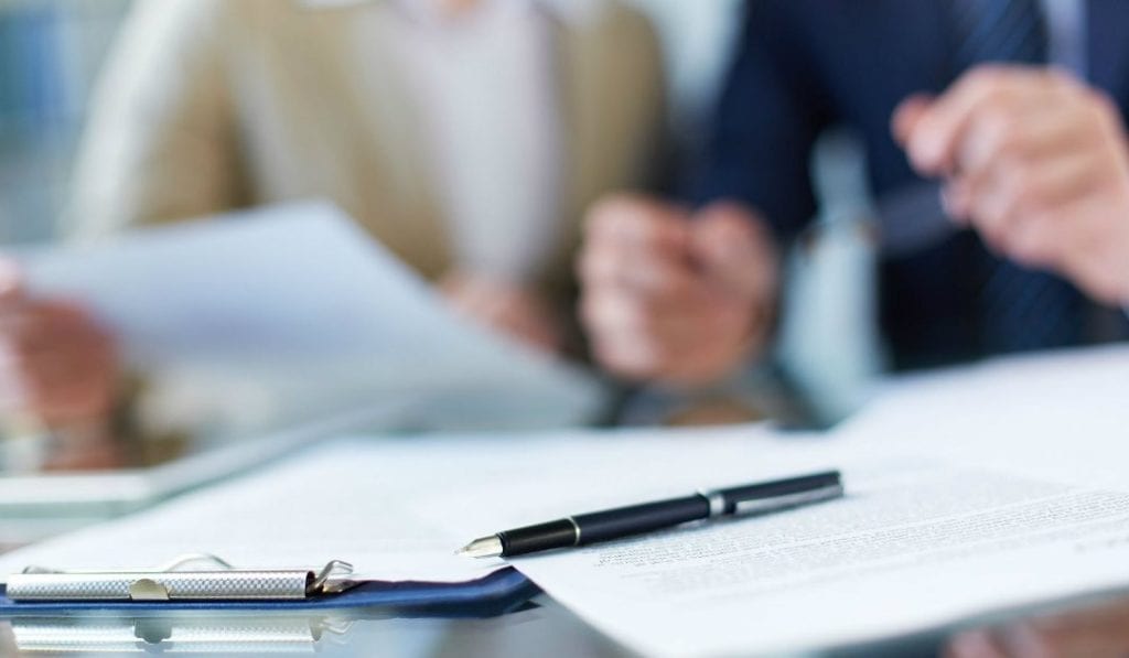 Como dar baixa na carteira de trabalho da empregada domestica - contratos e canetas sobre a mesa